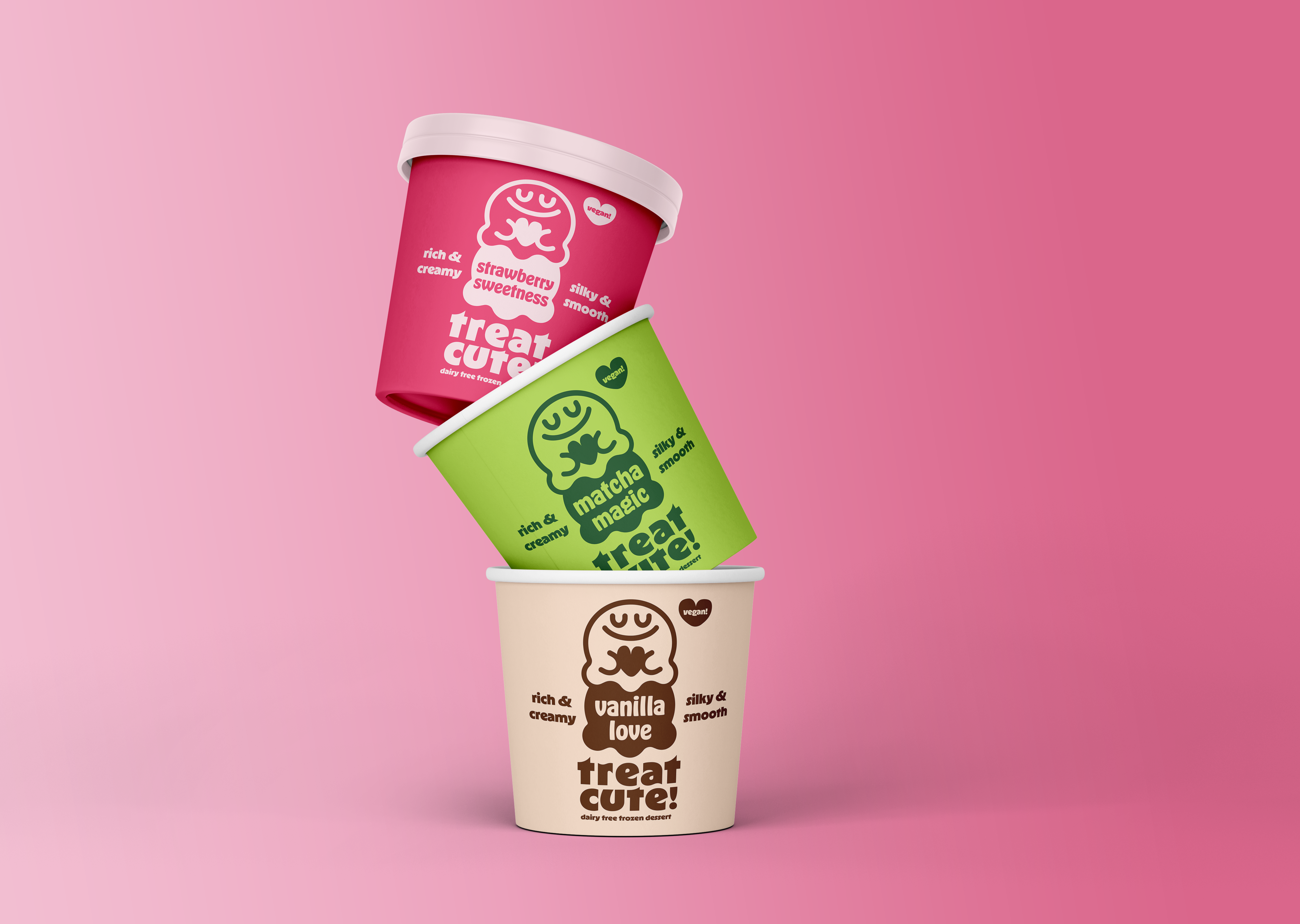 A stack of ice cream containers. At the bottom is the container for the flavor Vanilla Love. The package is off white and has no lid. Nested on top of Vanilla Love is the light green container for the flavor Matcha Magic. It also has no lid. Nested on top of Matcha Magic is Strawberry Sweetness. The container is a deep pink and this one does have a lid.